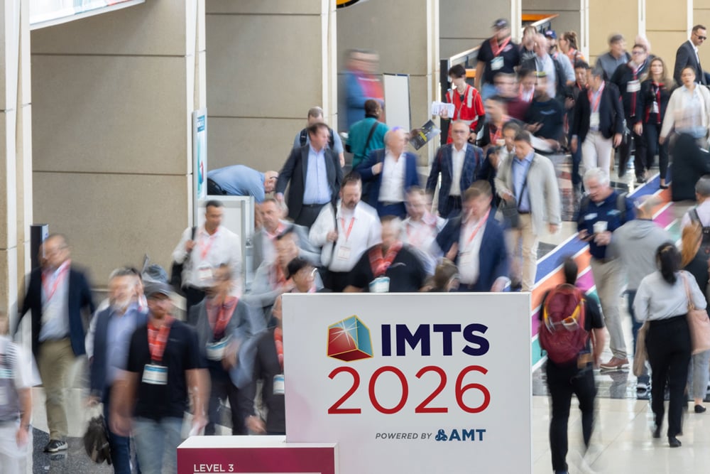 IMTS attendees flooding the halls by an IMTS sign IMTS attendees flooding the halls by an IMTS sign